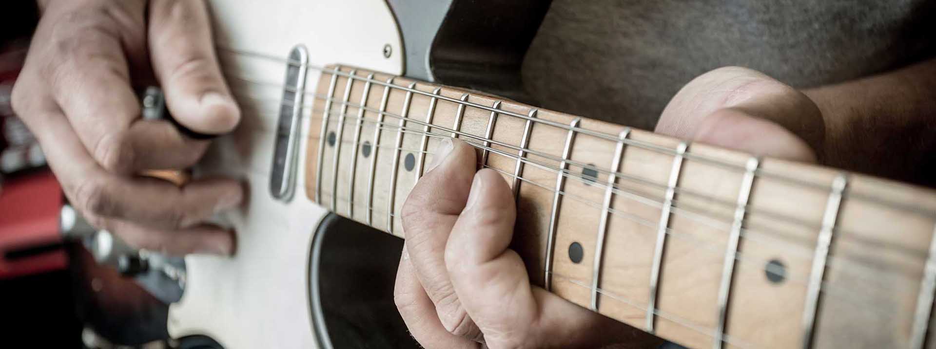 Händer spelar elgitarr